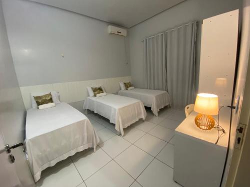a room with two beds and a lamp in it at Casa das Flores in Riachão