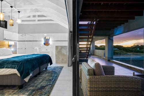 a bedroom with a bed and a balcony with a ladder at Flamingo Bay Manor in Fisherhaven