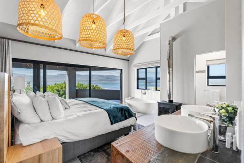 a bedroom with a bed and two sinks and a tub at Flamingo Bay Manor in Fisherhaven