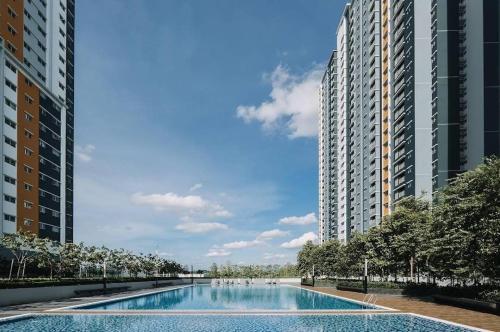 a swimming pool in the middle of two tall buildings at Casa D'Faiz Alanis near KLIA pool olympic size in Sepang