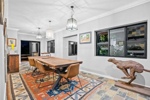 a dining room with a table and a dog statue at Flamingo Bay Manor in Fisherhaven