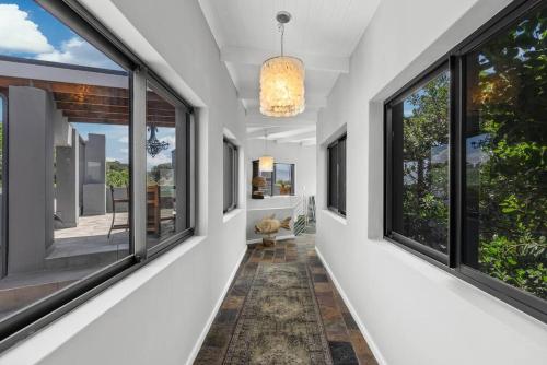 a hallway with large windows and a chandelier at Flamingo Bay Manor in Fisherhaven