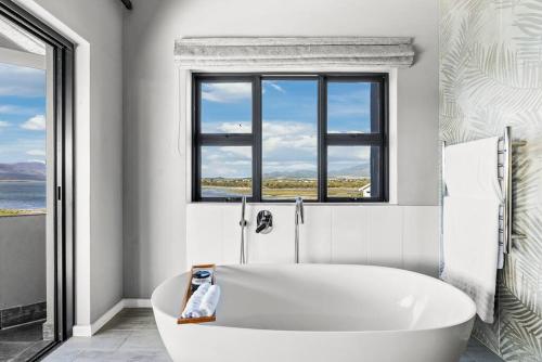 a white bath tub in a bathroom with windows at Flamingo Bay Manor in Fisherhaven