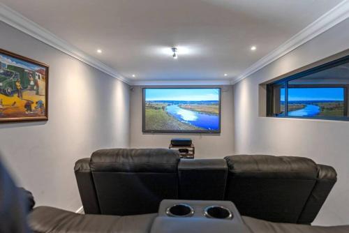 a living room with a couch and two large windows at Flamingo Bay Manor in Fisherhaven