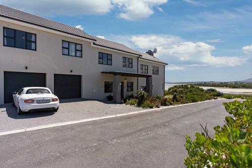 a white car parked in front of a house at Flamingo Bay Manor in Fisherhaven