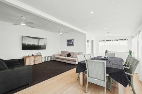 a living room with a table and a couch at Wamberal Beach(shares with Terrigal Beach)Terrigal Beach SummerBelle Beachfront House in Wamberal