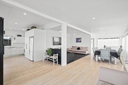 a white living room with a table and a couch at Wamberal Beach(shares with Terrigal Beach)Terrigal Beach SummerBelle Beachfront House in Wamberal