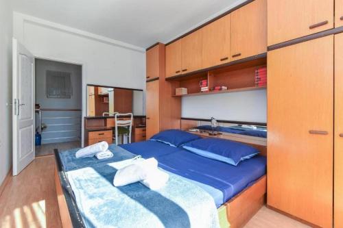 a bedroom with a blue bed and wooden cabinets at Seaside holiday house Zaton Veliki, Dubrovnik - 23195 in Zaton