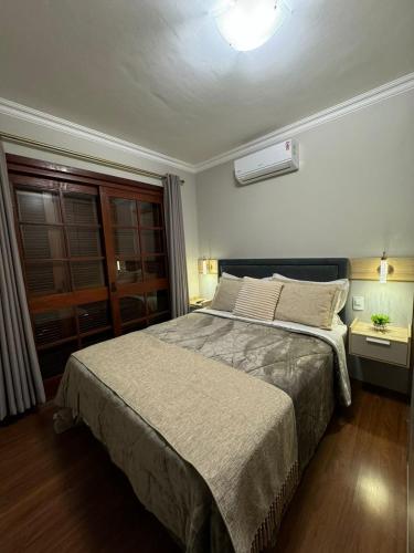 a bedroom with a large bed and a window at 3 dormitórios ao lado da Rua Coberta in Gramado