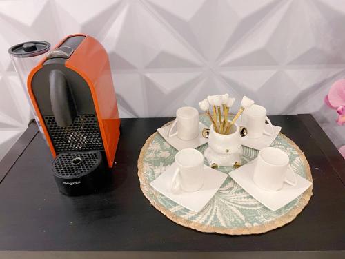 ein Tisch mit einem Telefon und Tassen auf einem Tisch in der Unterkunft Appartement de 4pieces Gennevilliers in Gennevilliers