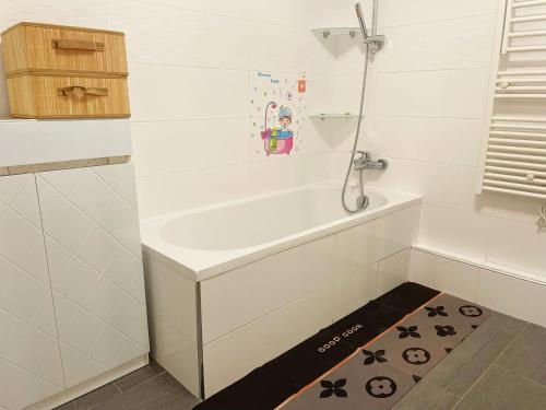 eine weiße Badewanne in einem Badezimmer mit Boden in der Unterkunft Appartement de 4pieces Gennevilliers in Gennevilliers