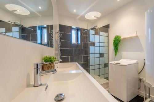 a bathroom with a sink and a toilet and a mirror at Superbe T3 spacieux et lumineux in Saint-Georges-de-Reneins