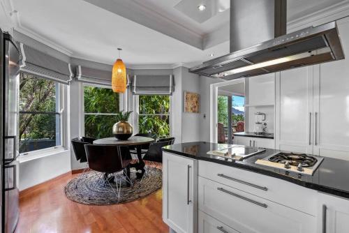 a kitchen with a table and some chairs in it at SunsetViews Houtbay in Hout Bay