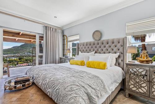 a bedroom with a large bed with a large window at SunsetViews Houtbay in Hout Bay