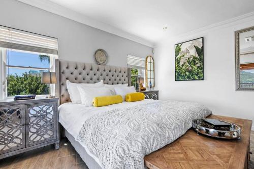 a bedroom with a large bed with two yellow pillows at SunsetViews Houtbay in Hout Bay