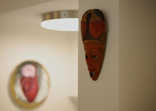 a wooden head hanging on a wall next to a mirror at Illuminati Guest House in Victoria