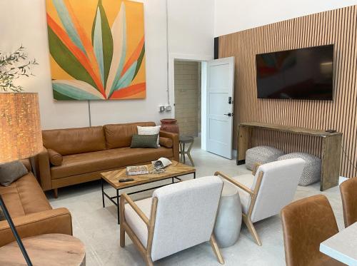 a living room with a couch and a tv at Fyrebird Place - Industrial Loft with Pavilion & Yard in San Antonio