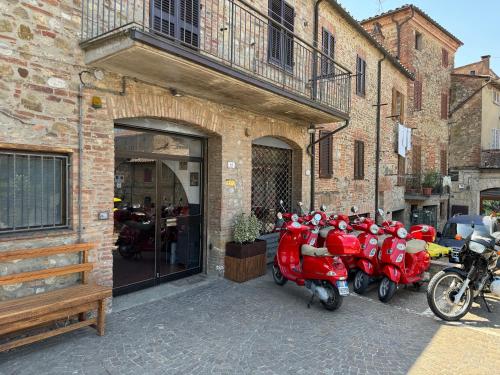 a row of red scooters parked in front of a building at 2 King Bed, 2 Full Bathroom Apartment in Umbria - Tuscany in Città della Pieve