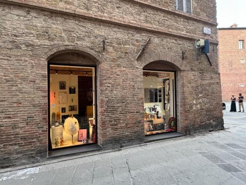 two windows of a brick building with items in them at 2 King Bed, 2 Full Bathroom Apartment in Umbria - Tuscany in Città della Pieve