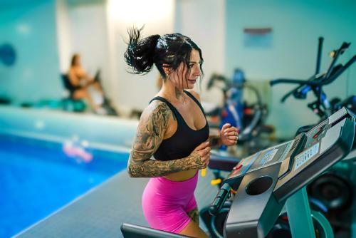 a woman running on a treadmill in a gym at Illuminati Guest House in Victoria