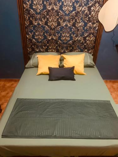 a bed with yellow pillows and a blue wall at Brás, Expo Center Norte, Vinho e Estacionamento Gráris, até 7 pessoas, Cozinha, ao lado do polo compras, tiers, valtier, feirinha in Sao Paulo