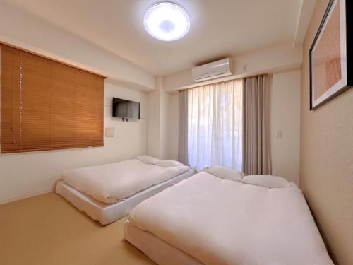 a hotel room with two beds and a window at Skyterrace Love Asakusa Downtown in Tokyo