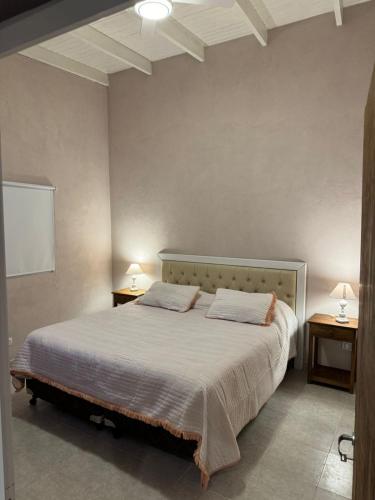 a bedroom with a large bed with two night stands at La Martina in Esquina