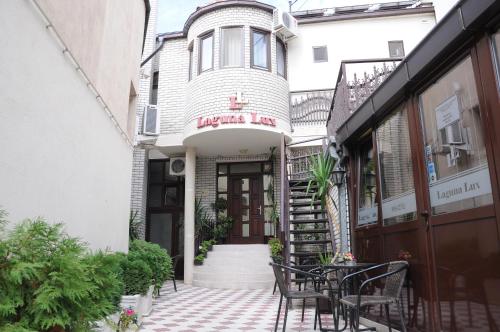 a building with a table and chairs in front of it at Garni Hotel Laguna Lux in Niš