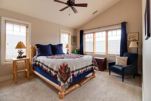 a bedroom with a bed and a chair and windows at Riley`s Mountain View in Sisters