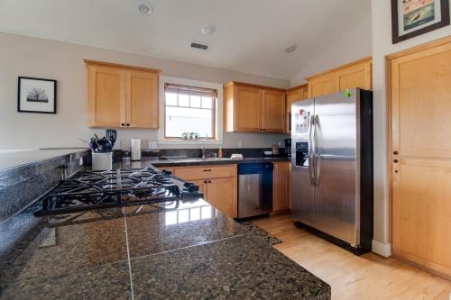 a kitchen with a stainless steel refrigerator and wooden cabinets at Riley`s Mountain View in Sisters