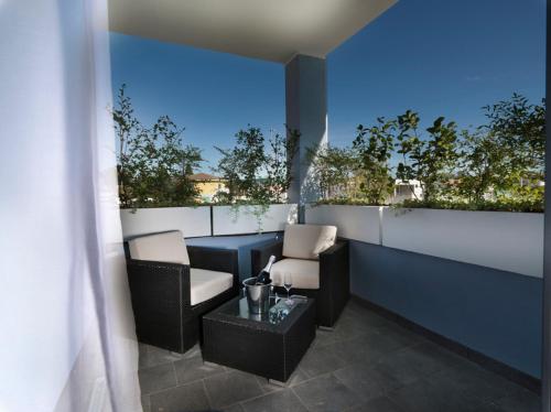 a balcony with two chairs and a table on a building at Blu9 Hotel in Novedrate