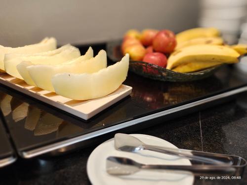 a tray of cheese and fruit on a table at Unity Hotel - Sorocaba in Sorocaba