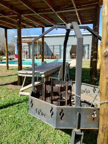 a picnic table and chairs under a pavilion near a pool at Hermosa Casa con piscina in Carlos Keen