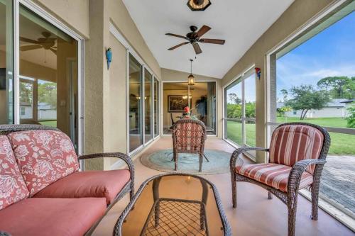 a porch with chairs and a couch and a fan at Casa Dell'Amore in Murdock