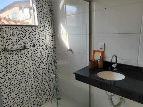 a bathroom with a sink and a shower at Casa espaçosa em frente à pracinha in Capitólio