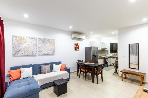 a living room with a blue couch and a kitchen at Green Villas Tamarindo in Tamarindo
