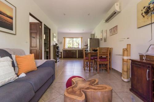 a living room with a blue couch and a kitchen at Green Villas Tamarindo in Tamarindo