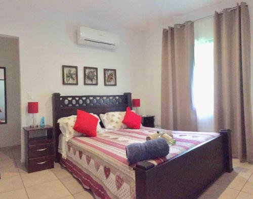 a bedroom with a large bed with red pillows at Green Villas Tamarindo in Tamarindo