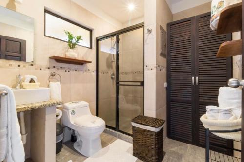a bathroom with a toilet and a sink and a shower at Green Villas Tamarindo in Tamarindo