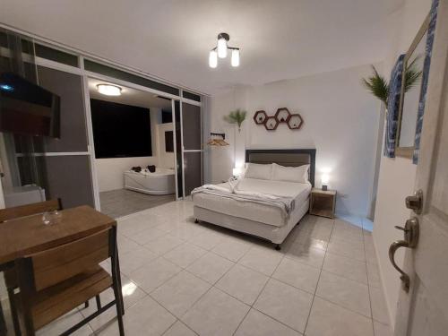 a large bedroom with a bed and a bathroom at Bonsai Jacuzzi Suites in Panglao