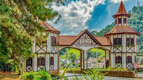 a building with a clock tower in a park at Casa de 2 quartos no Circuito das Aguas - Churrasqueira, fogão e forno a lenha in Lindóia