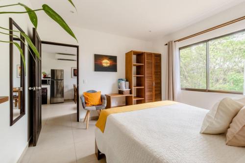 a bedroom with a white bed and a window at Green Villas Tamarindo in Tamarindo
