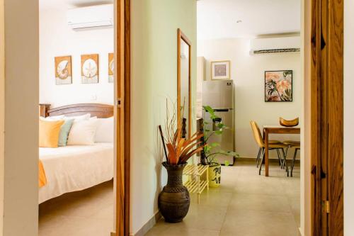 a bedroom with a bed and a vase in front of a mirror at Green Villas Tamarindo in Tamarindo