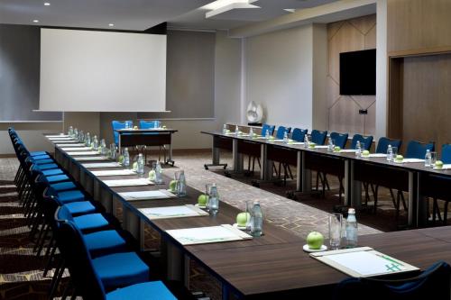 a conference room with long tables and blue chairs at Holiday Inn & Suites - Dubai Festival City by IHG in Dubai