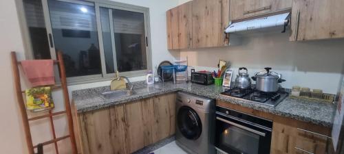 a kitchen with a stove and a dishwasher at Apprt Ennakhil 3 in El Jadida