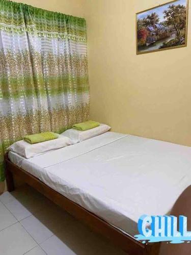 a small bed in a room with a window at DaLei Suites in Pamplona in Tambojangin