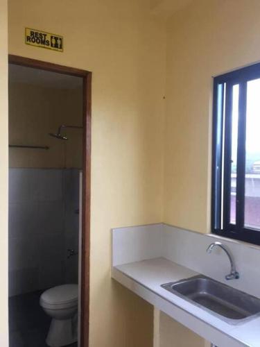 a bathroom with a sink and a toilet and a window at DaLei Suites in Pamplona in Tambojangin