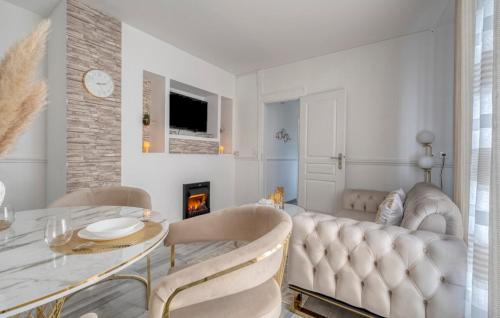 a living room with a table and chairs and a fireplace at ZACH & SPA - Maison jardin à 20 min de Paris & Aéroport CDG in Livry-Gargan