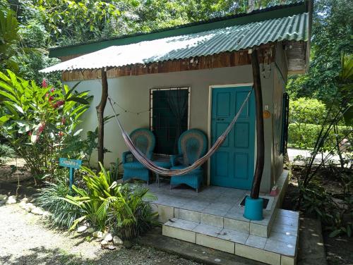 a small house with two chairs and a hammock at Tasty Dayz Hostel in Puerto Viejo