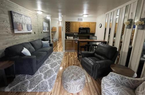 a living room with a couch and chairs and a kitchen at Blue Spruce Condo #134 in Ruidoso